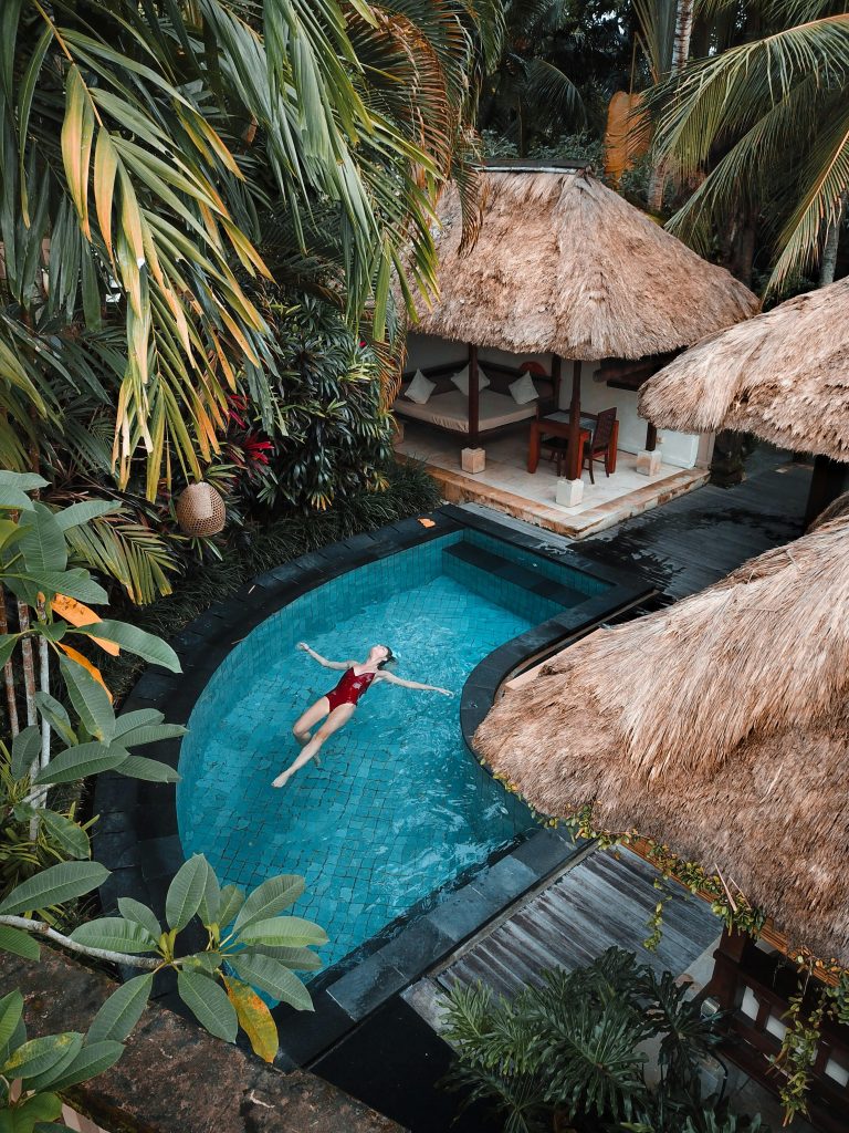 pexels photo 3225531 3225531 A woman enjoying leisure time floating in a tropical resort pool surrounded by lush greenery.