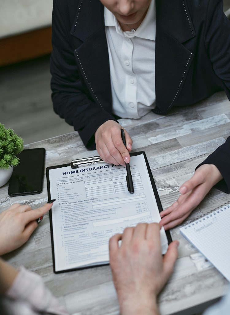 pexels photo 7731328 7731328 An agent and clients discussing paperwork for home insurance at a meeting table.